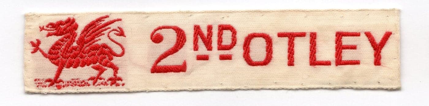 An embroidered 2nd Otley name tape bearing the red griffin from the founder’s family crest