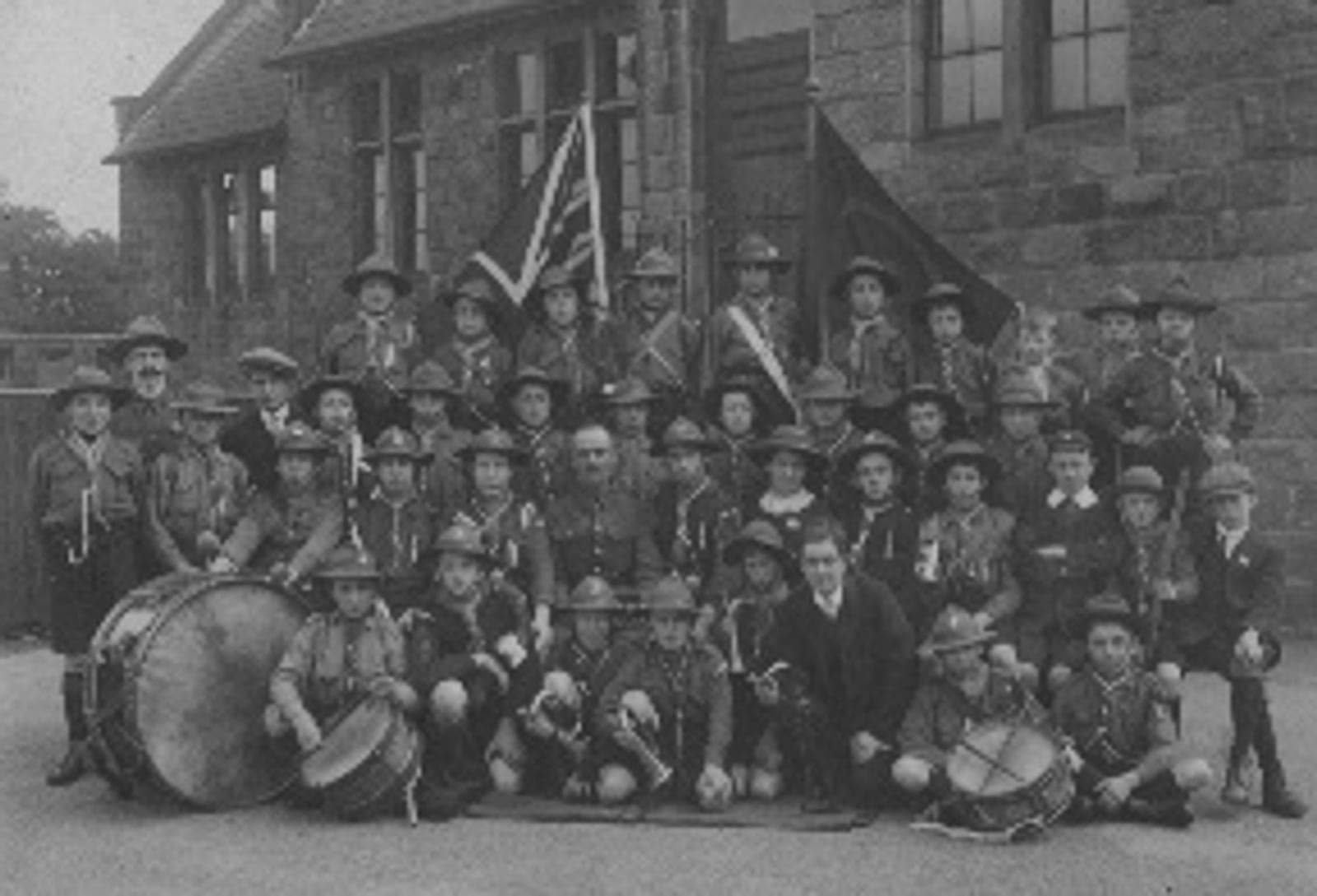 An early photograph of the 2nd Otley Scout troop and band outside their headquarters