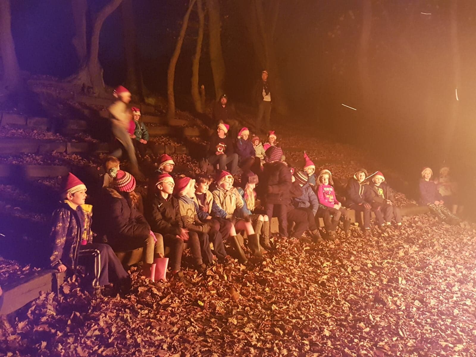 Gathered round the fire after dark at camp.