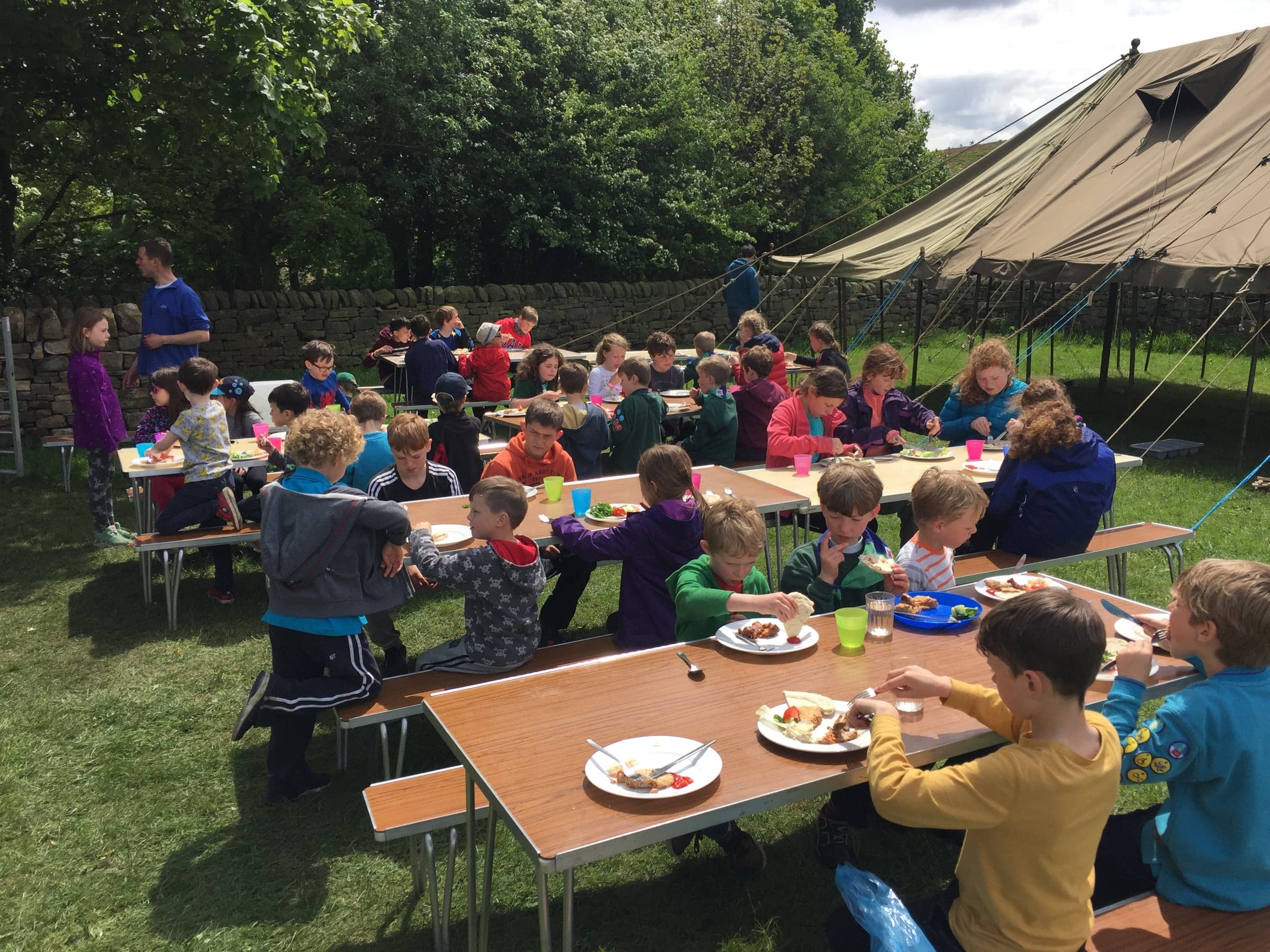 Mealtime under the awning at summer camp.